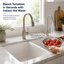 Kitchen sink with tomatoes being rinsed under hot water, featuring a modern Brushed Nickel faucet.