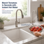 Kitchen sink with tomatoes being rinsed under hot water, featuring a modern Brushed Nickel faucet.