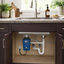 Blue disposer installed under a kitchen sink with visible pipes and an electrical outlet.
