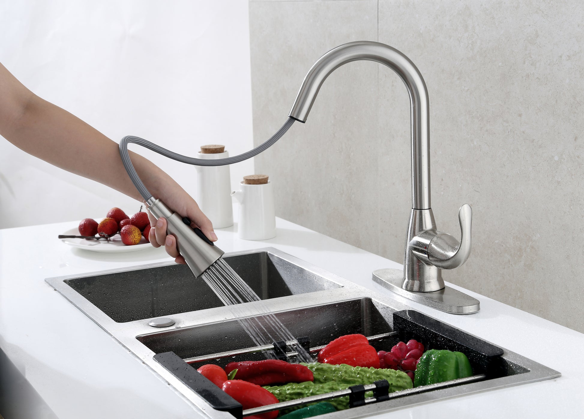 Alexis faucet with 20 inch reach rinsing off vegetables in a kitchen sink.